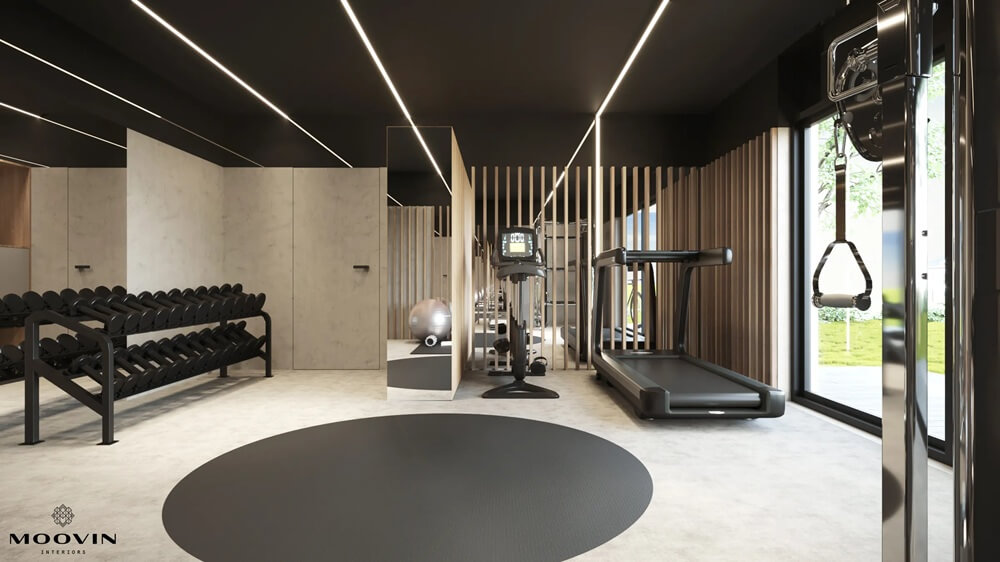 Цей сучасний мінімалістичний тренажерний зал був спроектований з урахуванням функціональності та естетики. Інтер'єр світлий та просторий, з великими дзеркалами та вертикальними дерев'яними панелями, що додають йому елегантності. Обладнання включає гантелі, бігову доріжку, еліптичний тренажер та кабельний тренажер, що дозволяє проводити різноманітні тренування. У центрі розташований круглий килимок, ідеально підходить для розтяжки або вправ з власною вагою. Велике вікно пропускає природне світло та пропонує вид на зелень, що сприяє розслабленню та концентрації.